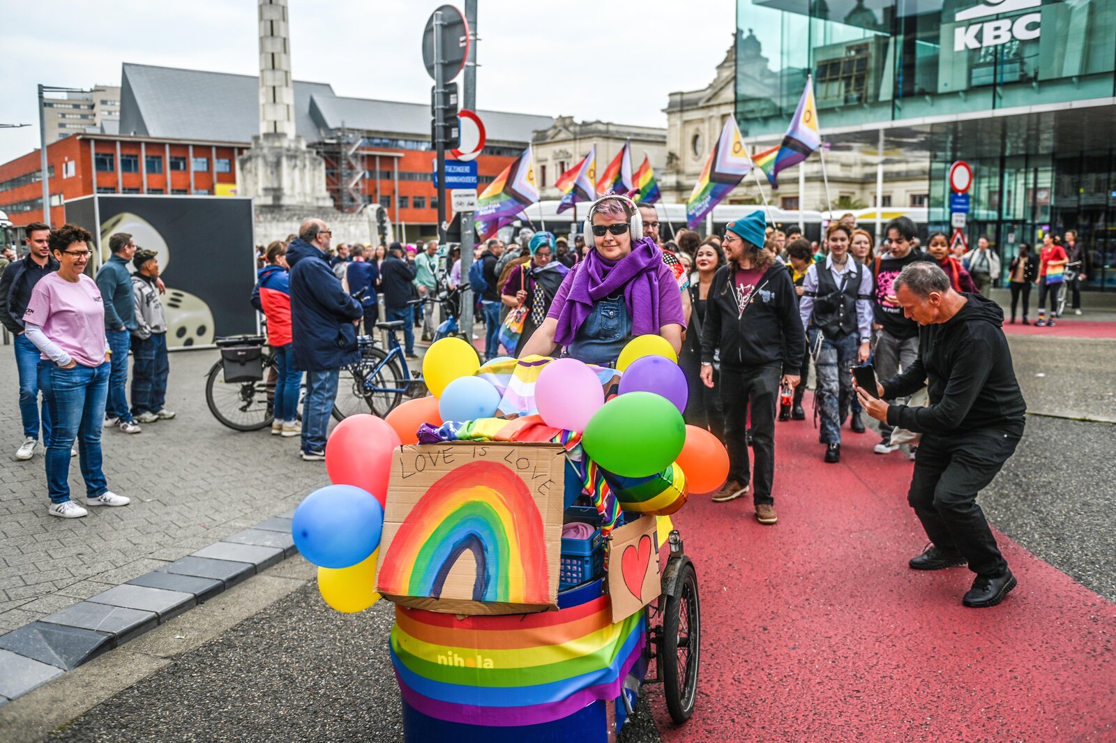 A cargo bike dressed in balloons and a painted rainbow joins the walk. Leuven Pride 2025, photo: Koen Bauters