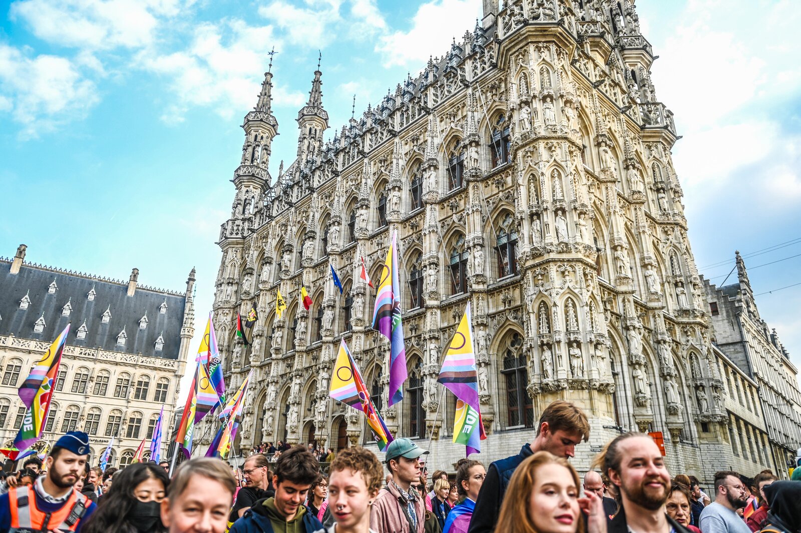 The crowd gathers with flags in front of the town hall. Leuven Pride 2025, photo: Koen Bauters