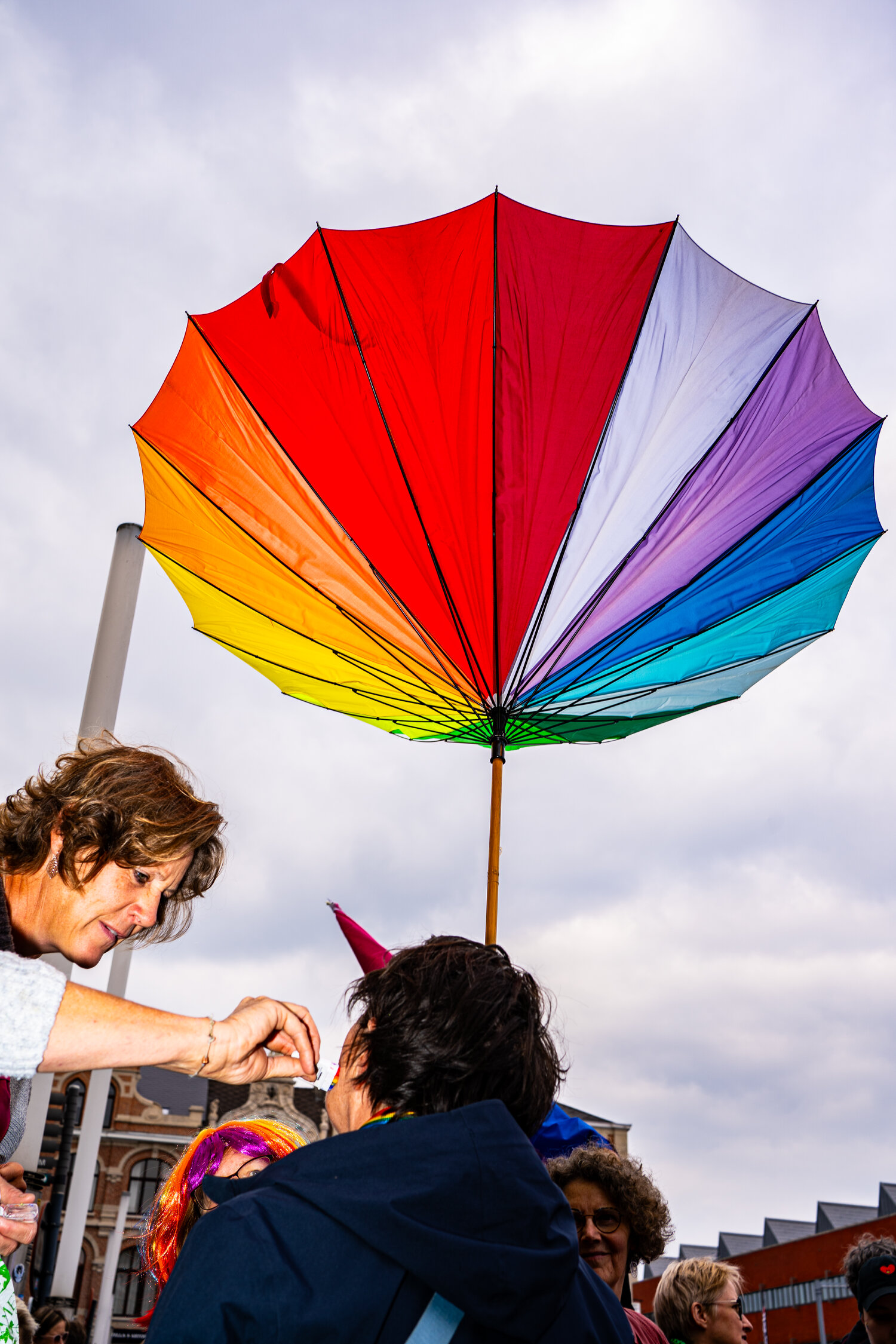 A rainbow umbrella held up against the sky. Leuven Pride 2025, photo: Frederic De Blauwe
