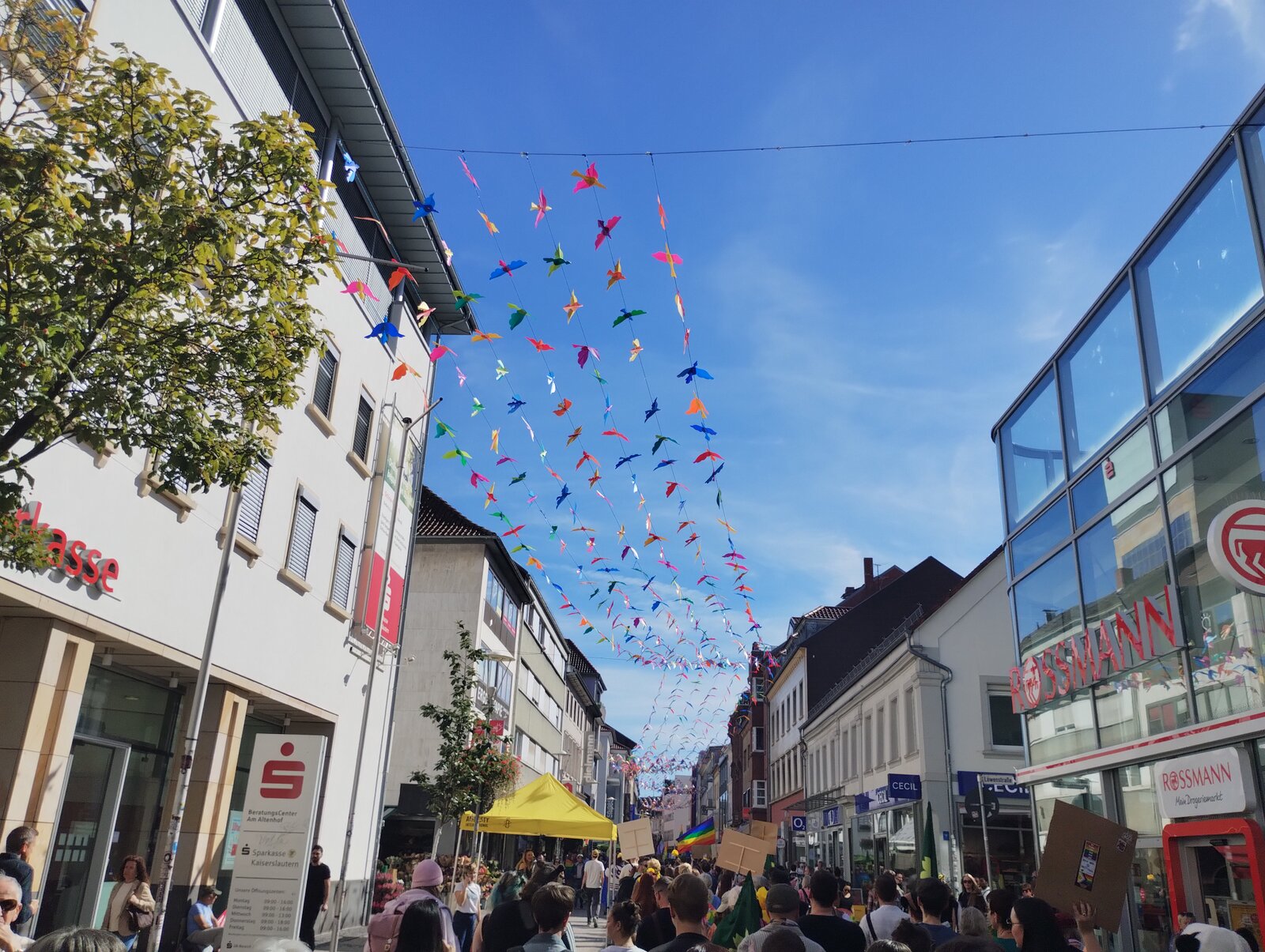 Paper birds in every colour hanging over the shopping street on the day of the march. CSD Lautre 2026, photo: gaycation.eu