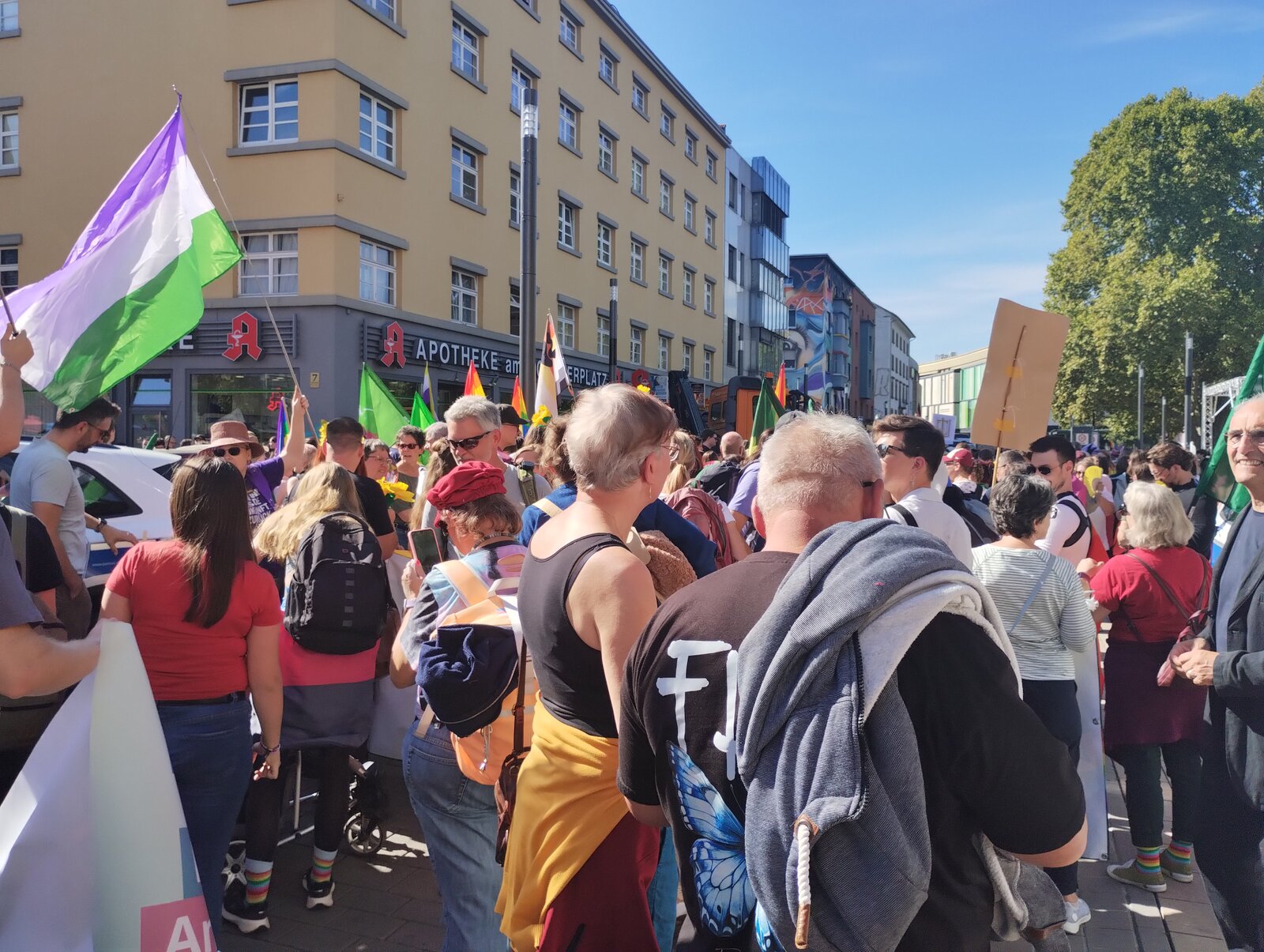Flags going up among the crowd gathering in the city centre before the march. CSD Lautre 2026, photo: gaycation.eu
