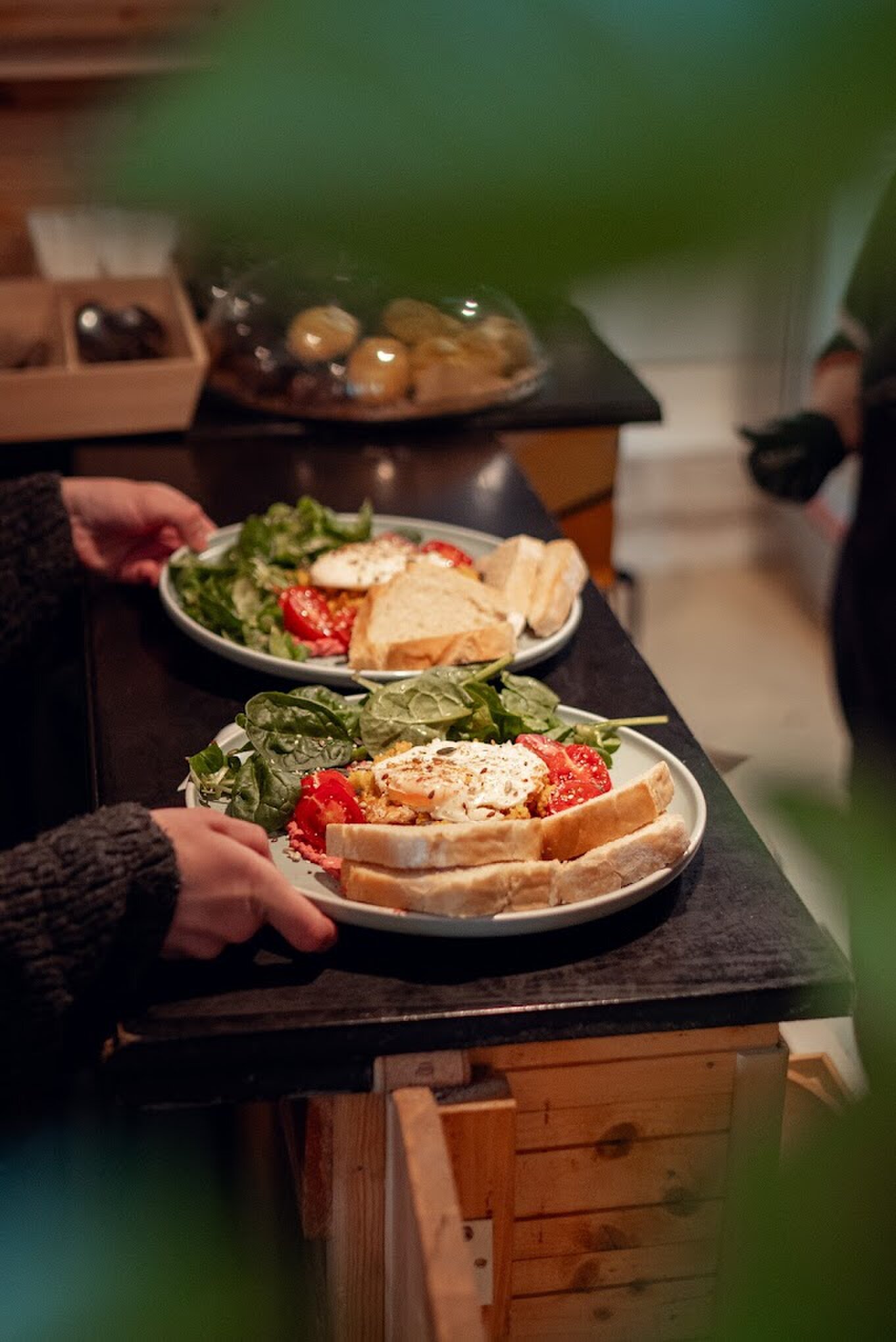 Two breakfast plates being served over the counter.