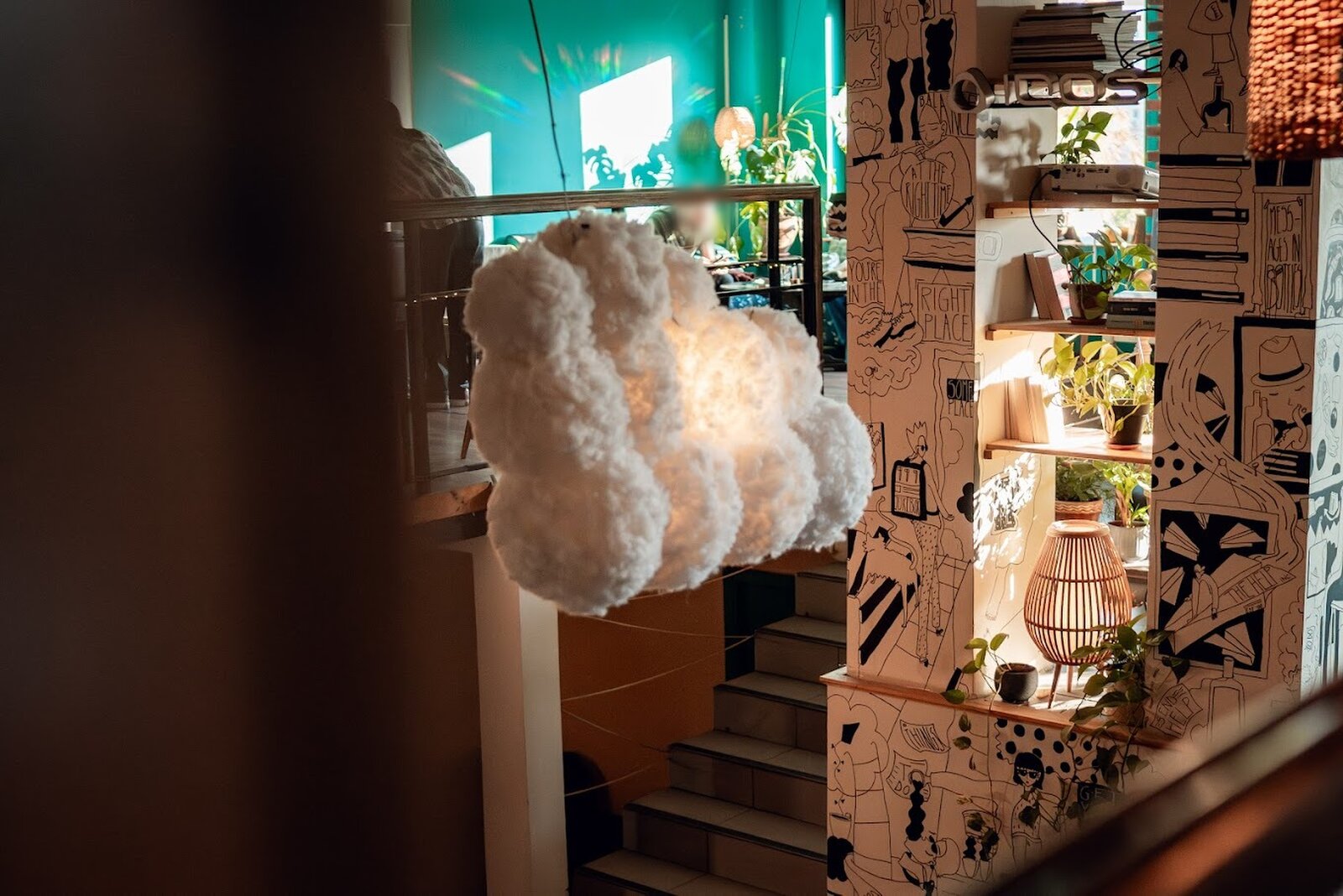 The cloud-shaped lamp above the staircase, beside the illustrated wall.