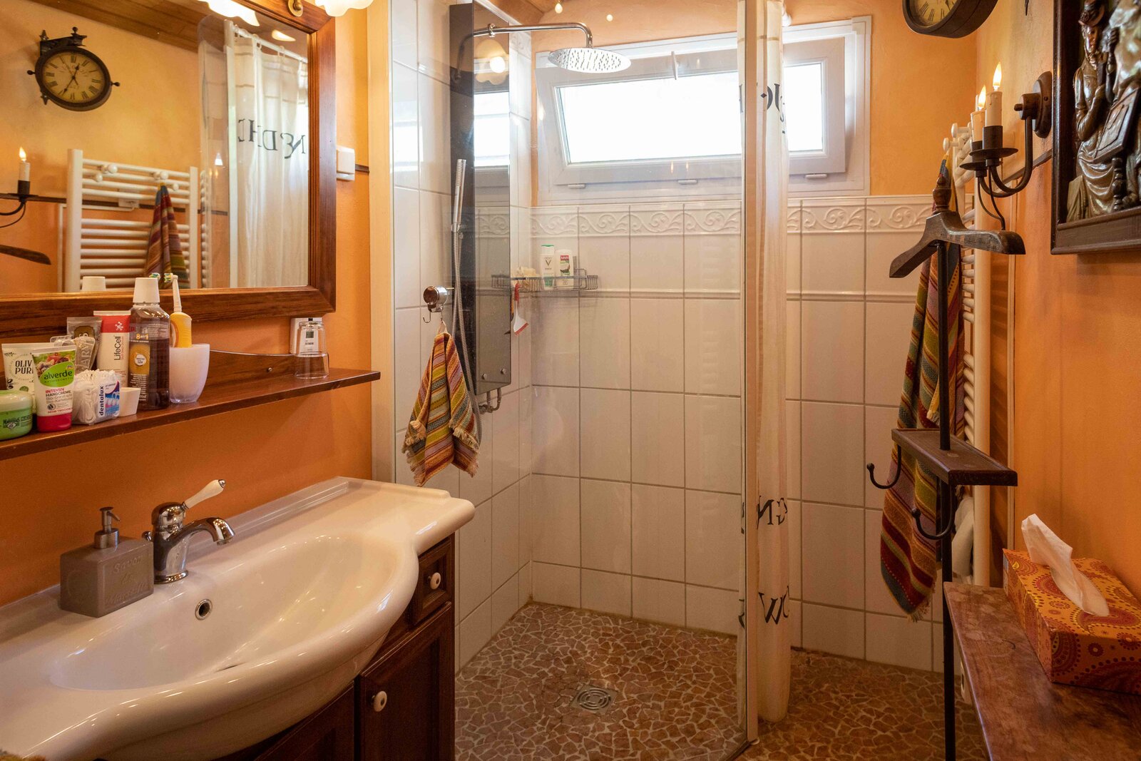 The shared shower room, with a walk-in shower and warm orange walls