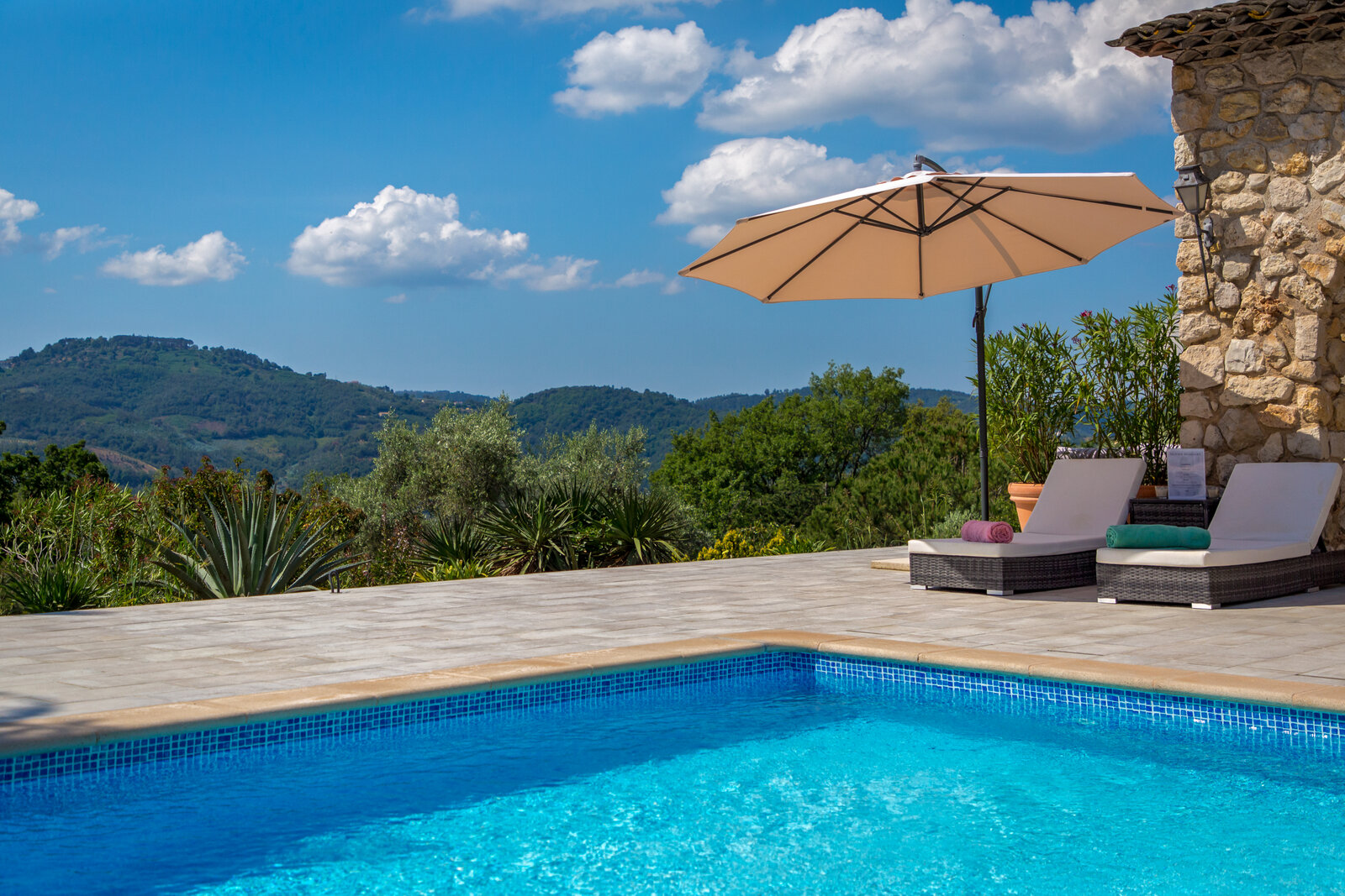 The pool and sun loungers, with the hills beyond.