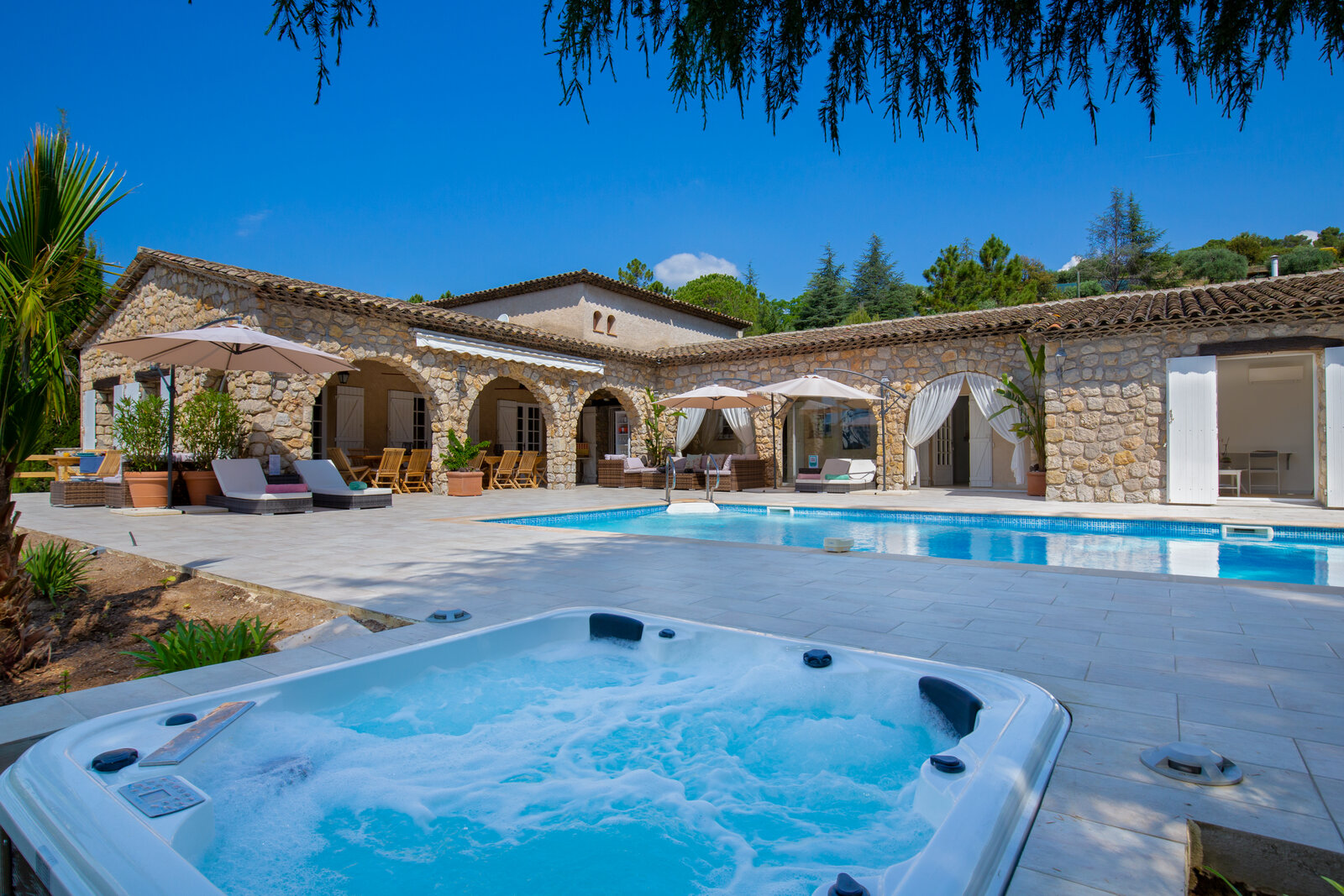 The pool and terrace, with a hot tub in the foreground.