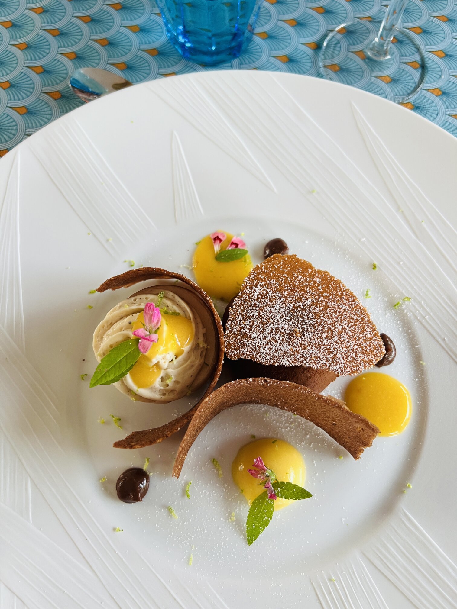 A mango and chocolate dessert with a meringue shard.