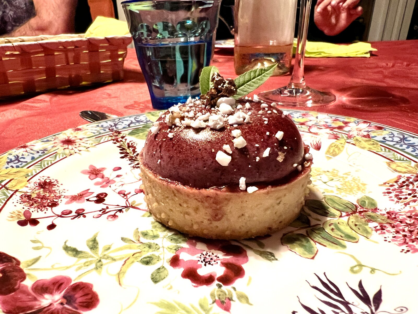 A dome-shaped dessert with a fruit glaze and crushed meringue.