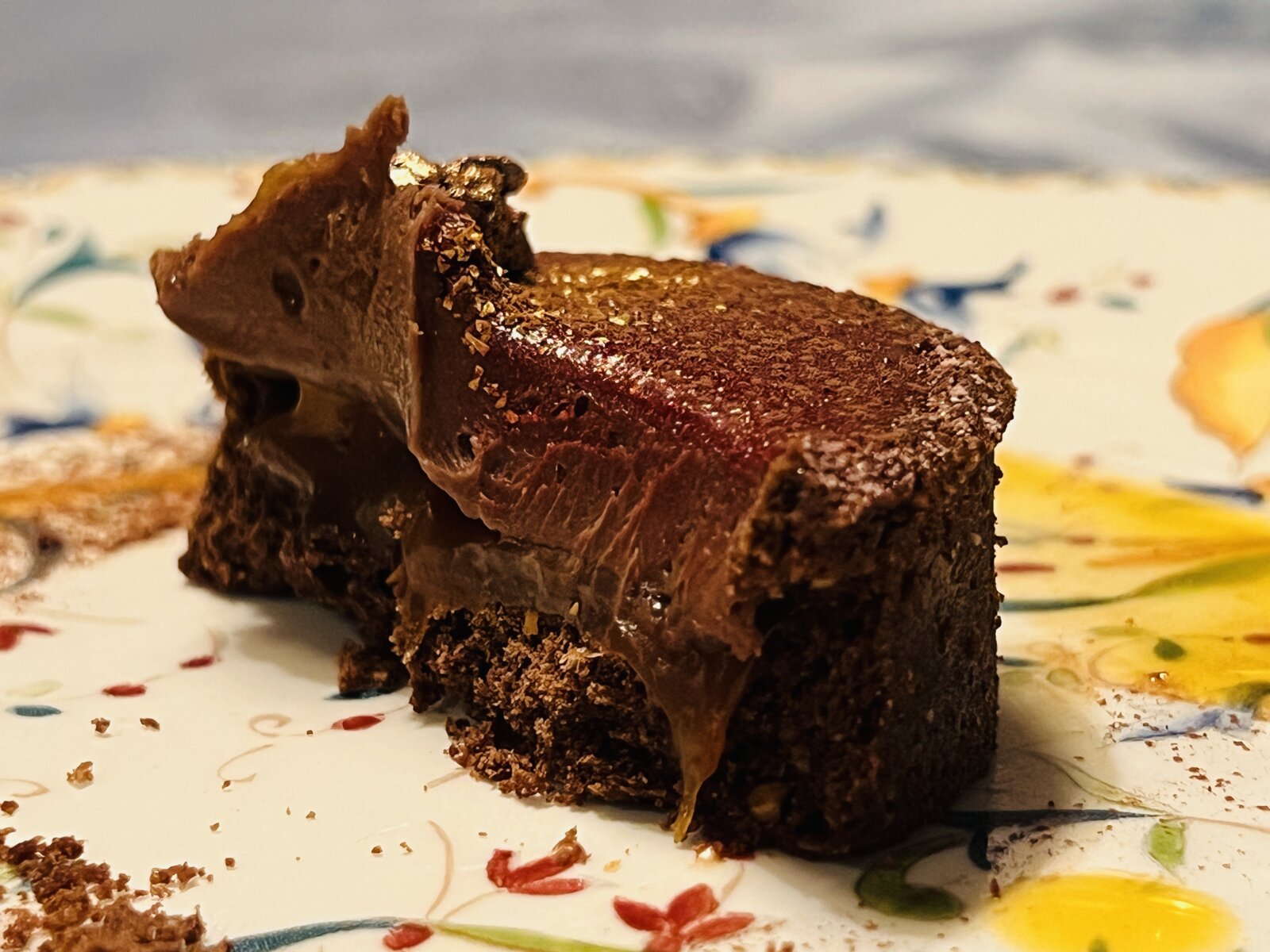 A chocolate dessert with gold leaf, cut open.