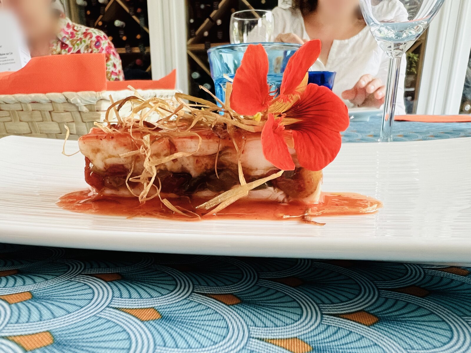 A plated dish garnished with a nasturtium flower.