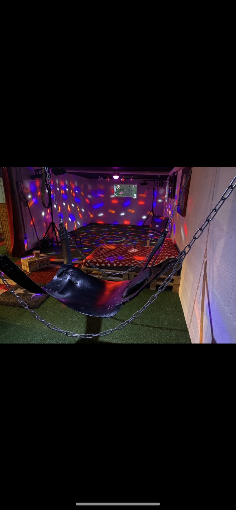 A play room with a suspended sling and disco lighting.