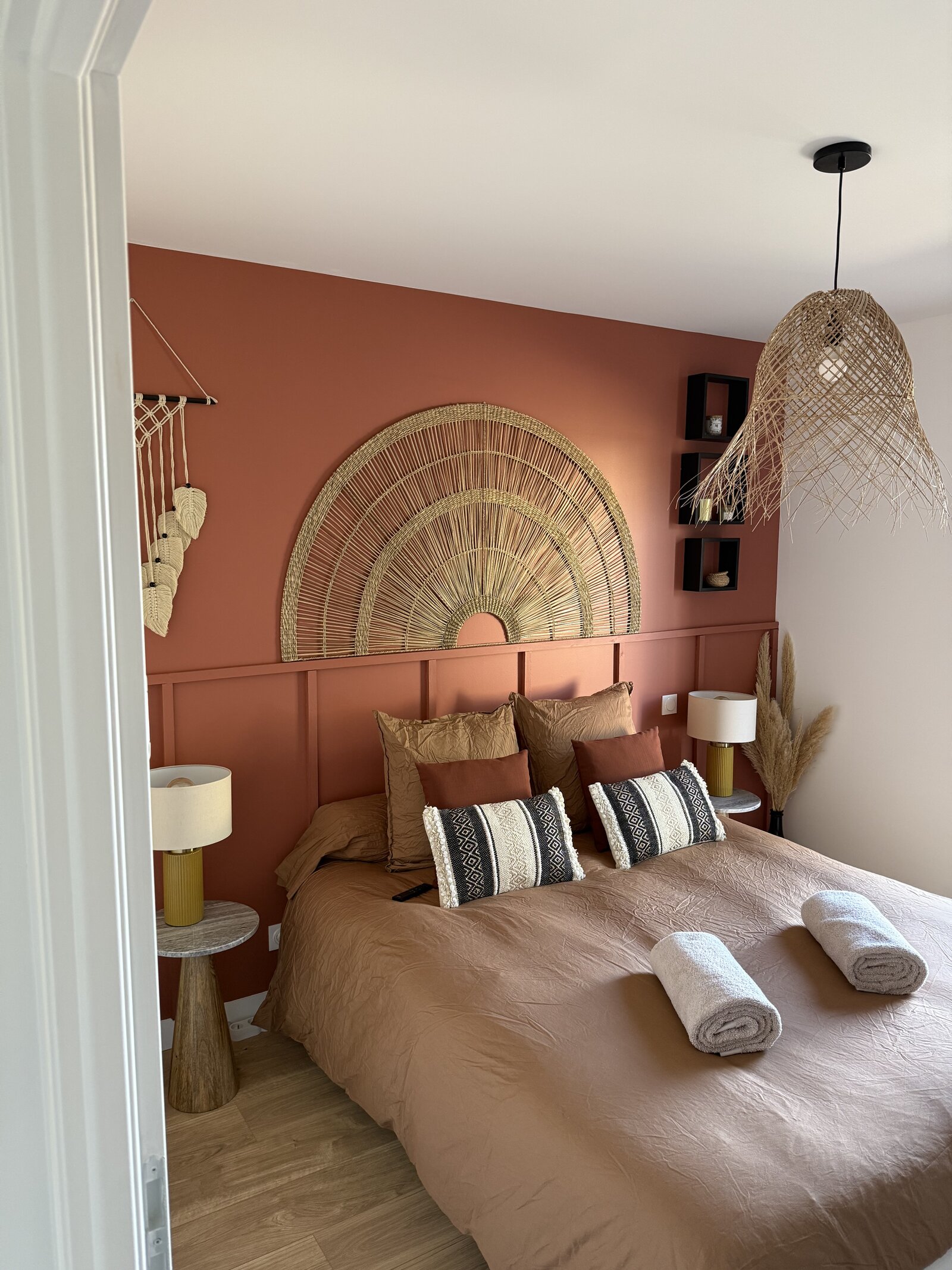 Close-up of the terracotta room's bed and rattan wall decoration.