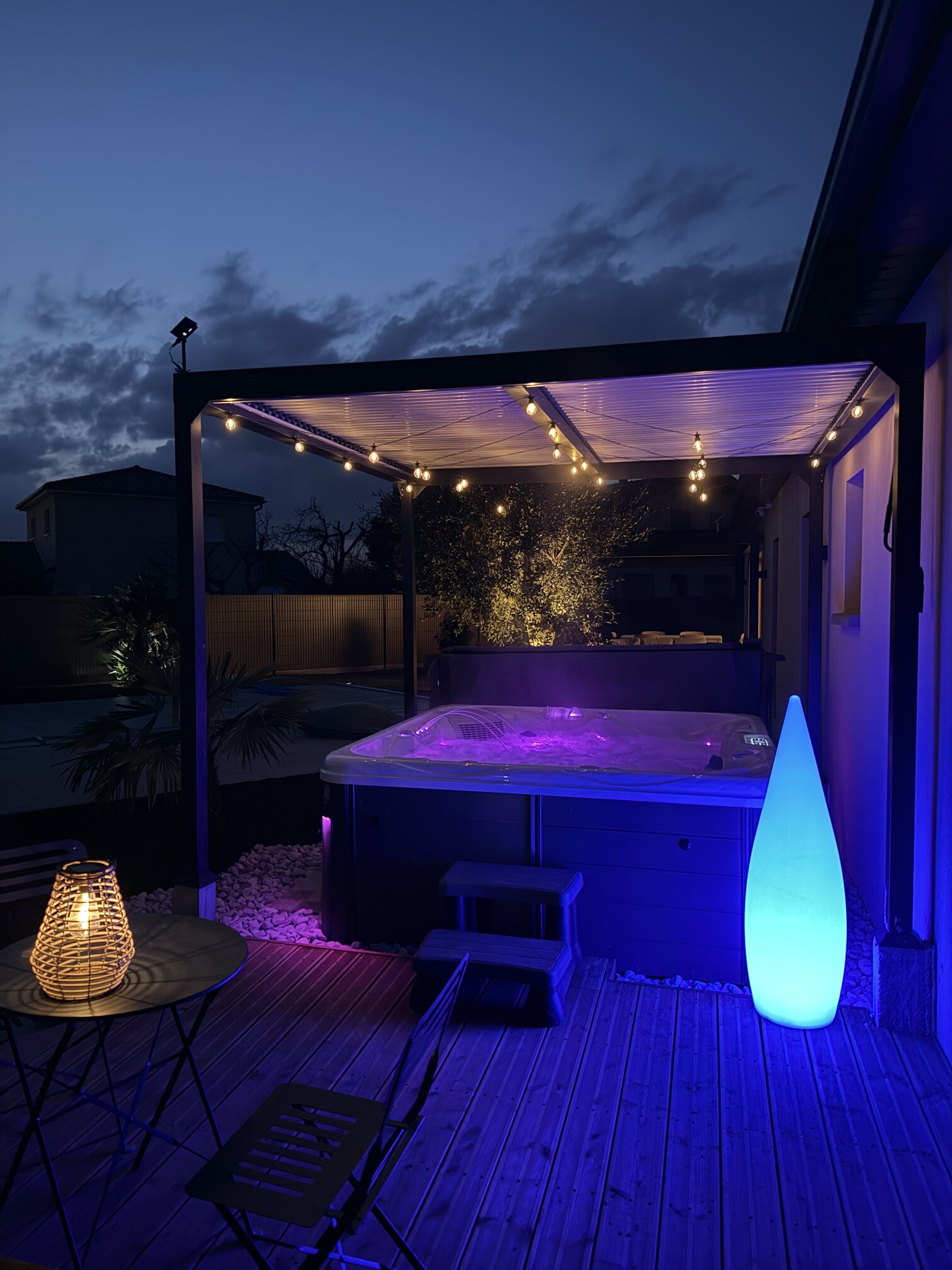 The hot tub lit up on the covered terrace in the evening.