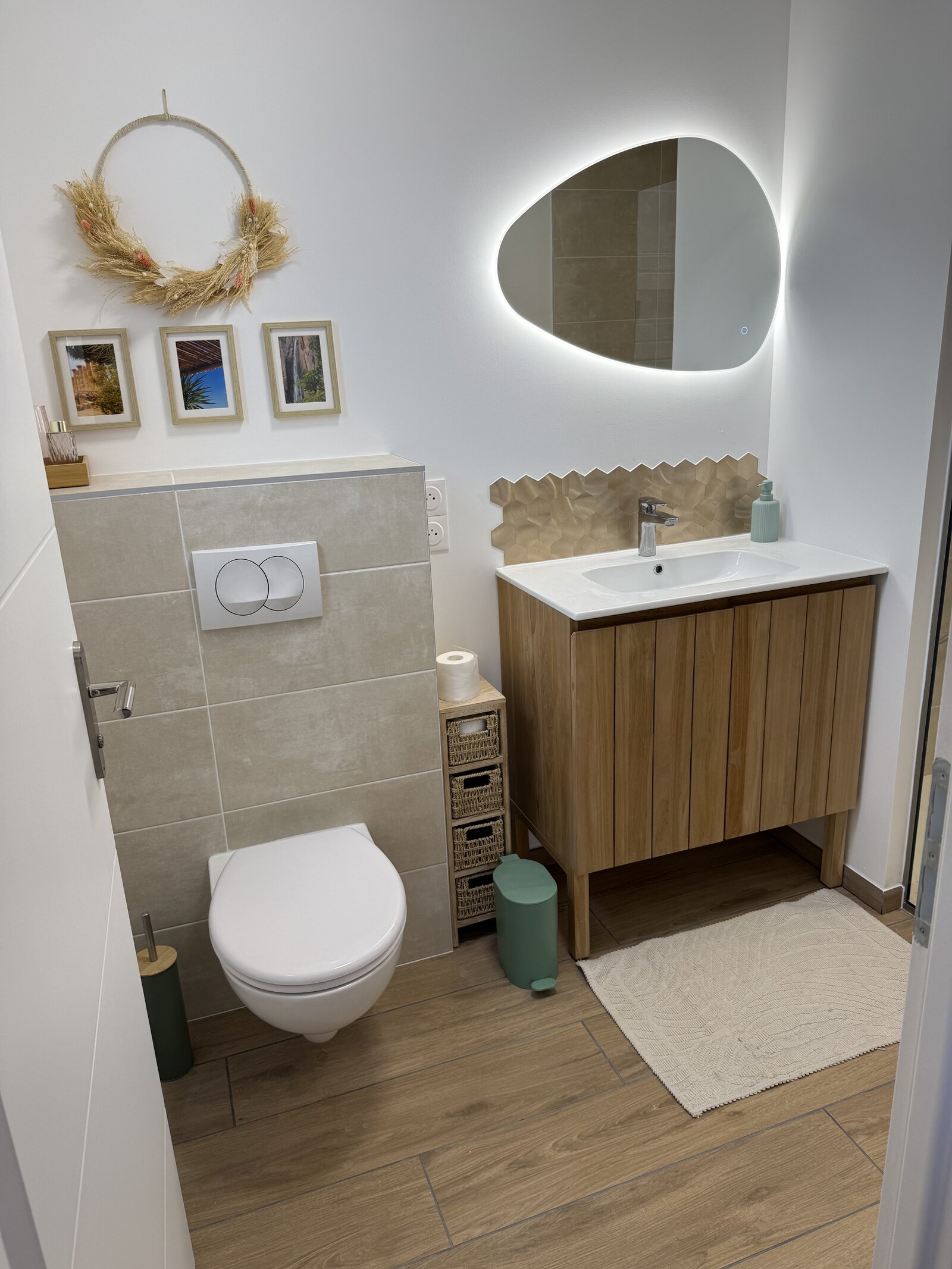 One of the guest bathrooms, with a round mirror and wood vanity.