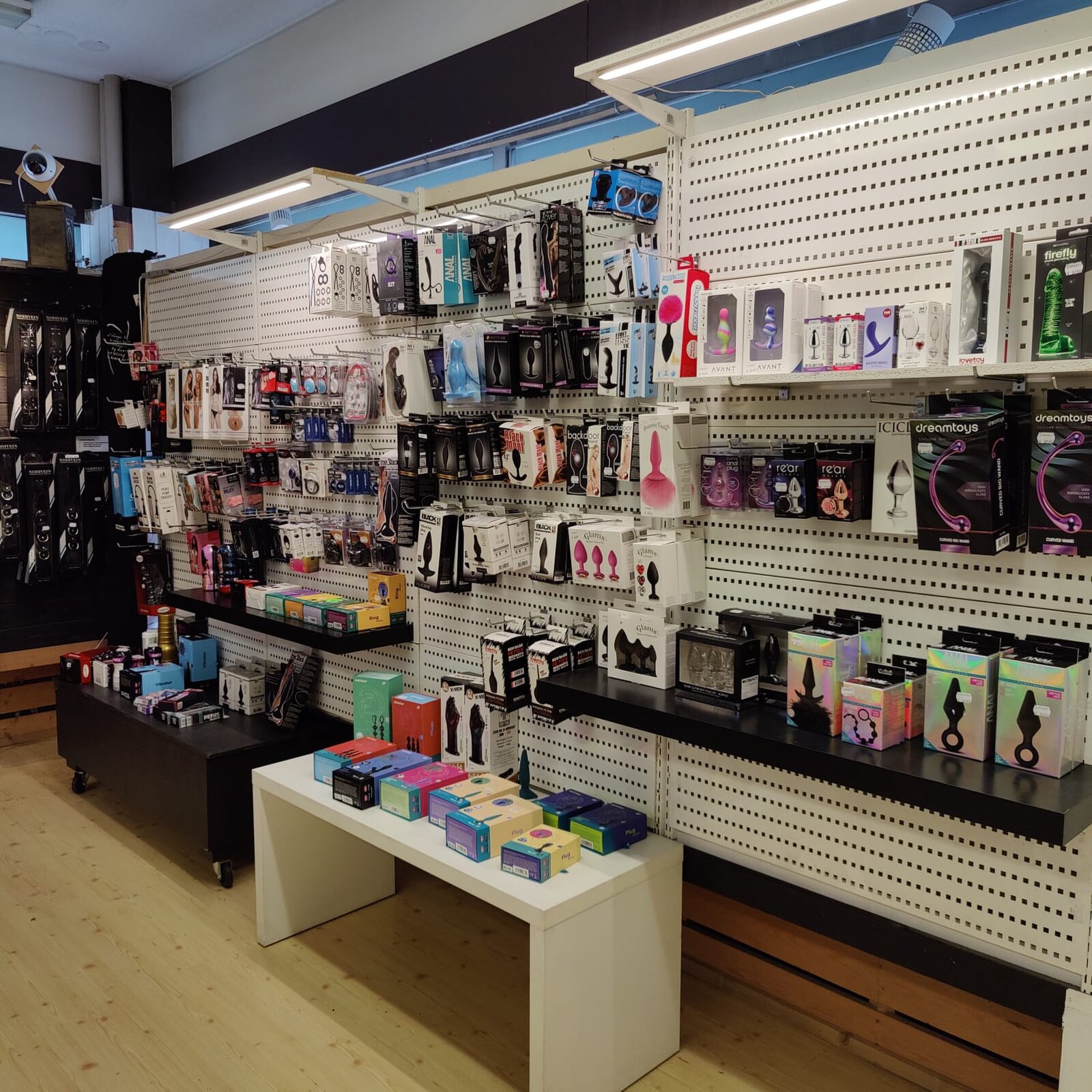 Shop floor with a pegboard wall of plugs, rings and other toys, and a display table in front