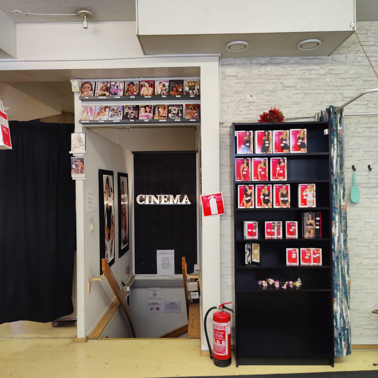 Stairs down to the cinema, with DVDs above the entrance and a shelf of lingerie beside it