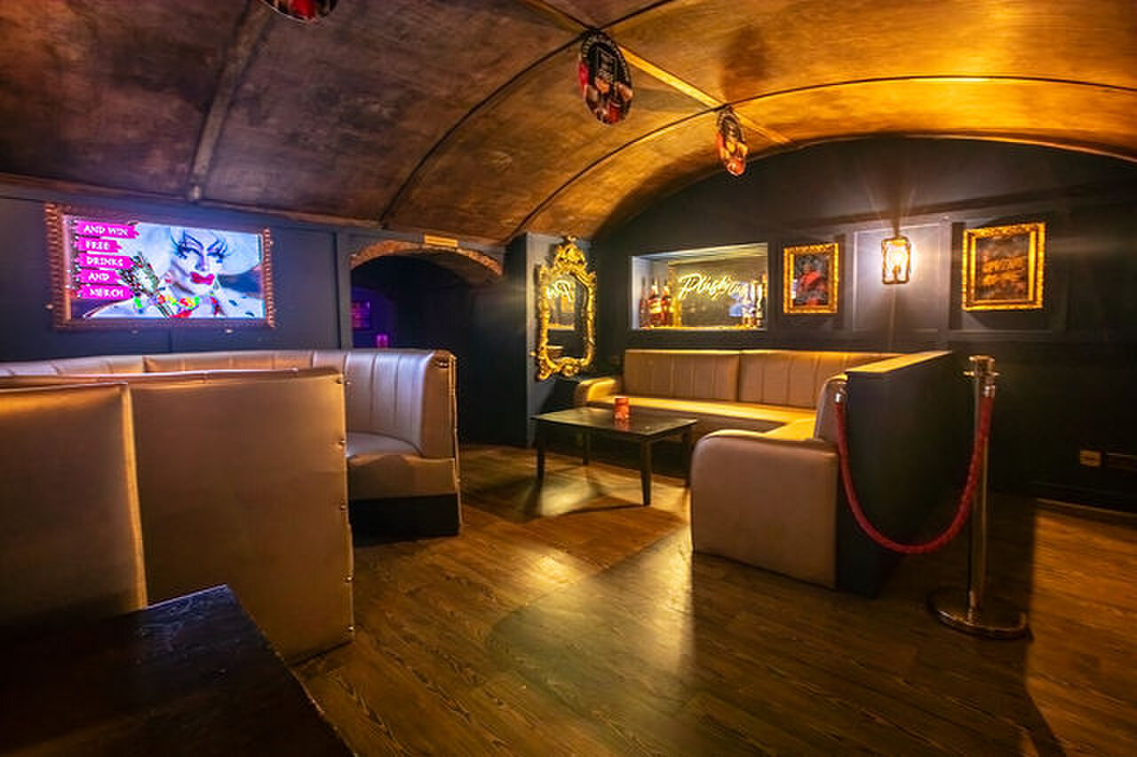 The front bar lounge under a gold vaulted ceiling, with leather booths and gilt-framed mirrors.