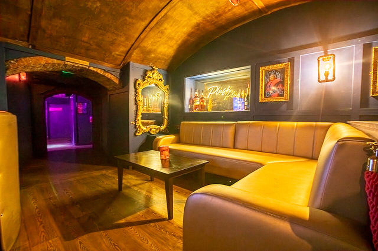 A corner sofa in the front bar lounge, with an arch through to the club beyond.