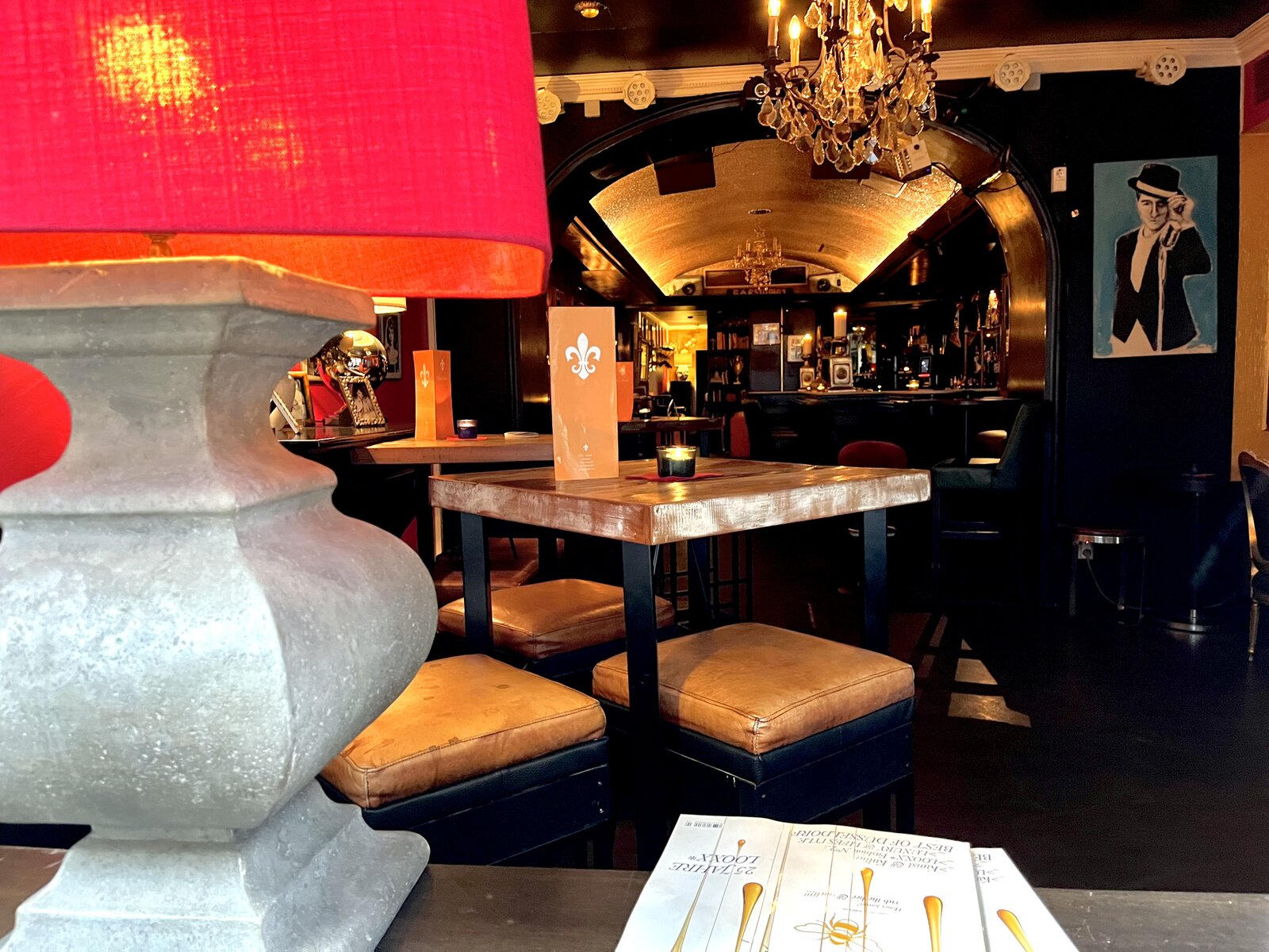 The front lounge under a chandelier, with a '25 Jahre' anniversary award card on the table.
