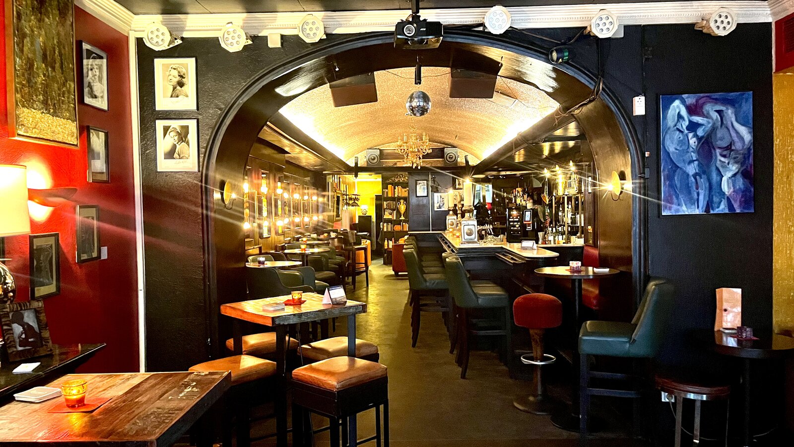 A view through the archway from the front lounge to the long bar at the back of the room.