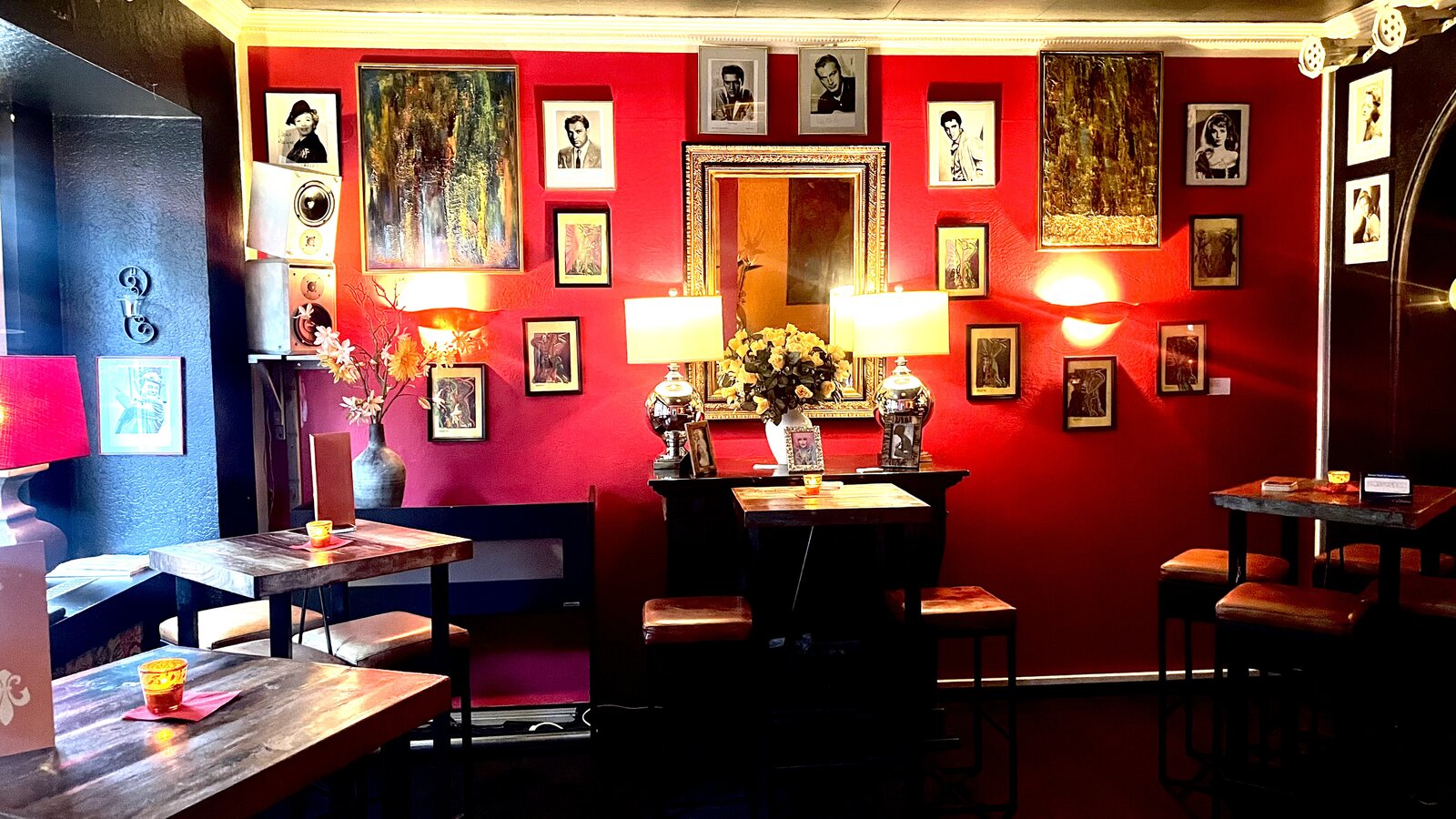 The red lounge area, with a gallery of framed portraits above the standing tables.