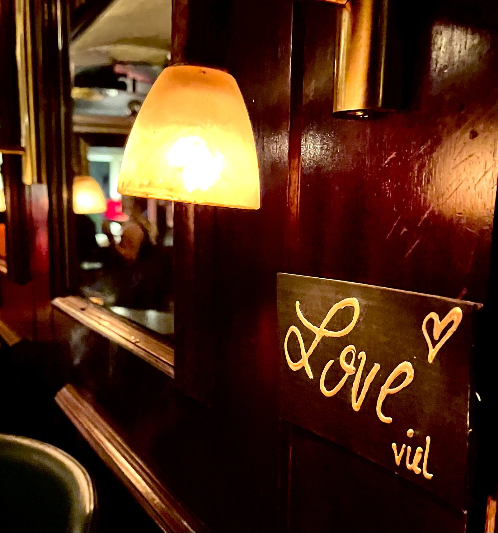 A hand-lettered 'Love' sign on the dark wood-panelled wall inside.